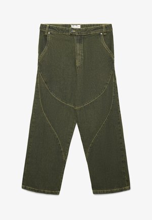 Pantaloni in denim verde a gamba larga con design a pannello curvo, cuciture gialle e tasche frontali. Presentano una chiusura con bottone e passanti per la cintura.