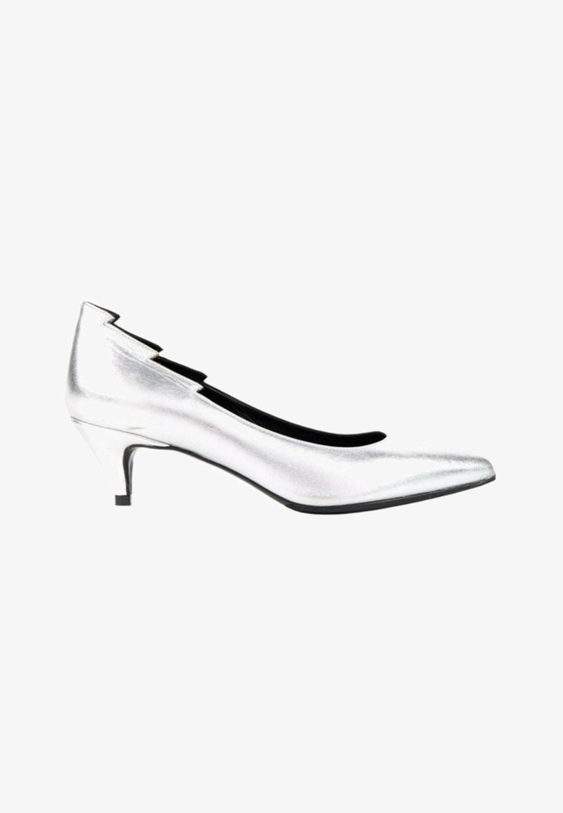 Escarpin argenté talon bas à bout pointu, ligne supérieure festonnée et doublure intérieure noire, présenté de côté sur fond blanc.