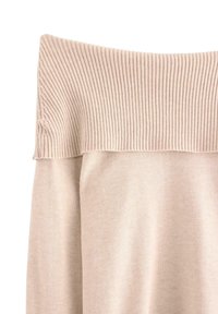 Sweter typu off-the-shoulder w jasnym beżu, z prążkowanym dekoltem, miękką teksturą i luźnym krojem. Prosty design bez wzorów.