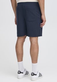 Tumesinised puuvillased püksid, millel on elastne vöökoht ja üks tagatasku. Sobivad kokku valgete tossude ja sokkidega.