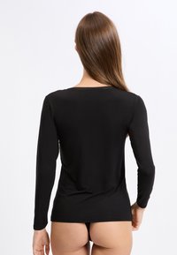 Czarna bluzka z długim rękawem o gładkiej fakturze, z okrągłym dekoltem i misternym przeszyciem wzdłuż szwu tylnego.