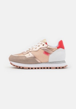 Rose gold and beige sneaker with white sole, red heel accent, textured rubber outsole, and fabric side panel with brand tag.