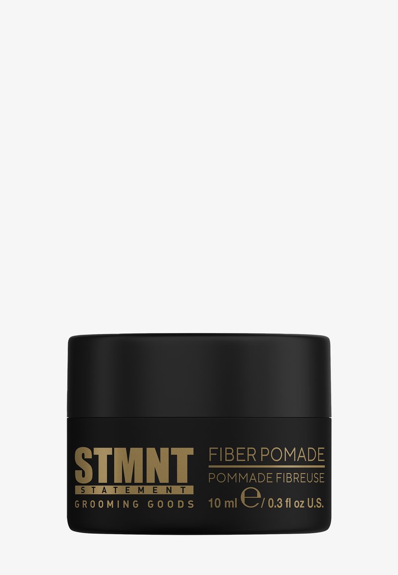 Svart behållare av STMTN Fiber Pomade med guldfärgad text, 10 ml storlek, med en slät yta och enkel, rund form.