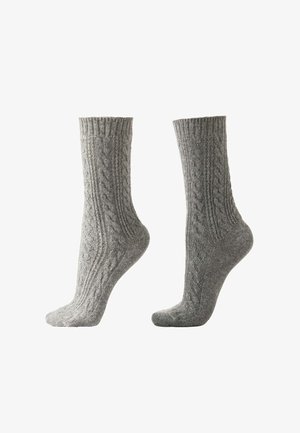 Grå stickade strumpor med ett texturerat kabelmönster, ribbade manschetter och en lätt förstärkt häl. Mjukt, design i medellång längd.
