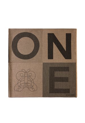 Un textile marron avec de grandes lettres noires écrivant "UN" et un design orné en bas à gauche. Le matériau présente une texture tissée.