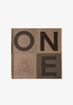 Un textile marron avec de grandes lettres noires écrivant "UN" et un design orné en bas à gauche. Le matériau présente une texture tissée.