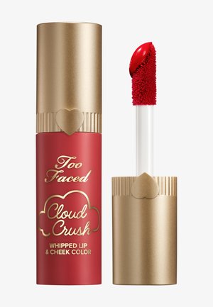 Red tube of Too Faced Cloud Crush Whipped Lip & Cheek Color, capped with a gold container featuring ridged accents and a heart detail.