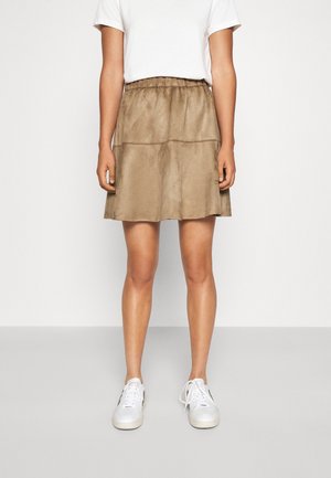 Brown, suede-like skirt with a tiered design and elastic waistband, paired with a plain white t-shirt and white sneakers.