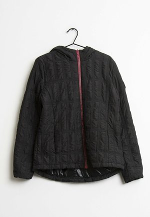 Veste matelassée noire à capuche avec fermeture éclair rose à l'avant, suspendue sur un cintre noir sur fond blanc.