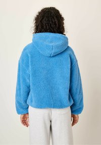 Blauwe, fuzzy fleece hoodie met een snug fit, voorzien van een capuchon, brede mouwen en een cropped lengte. Zacht van structuur en casual design.