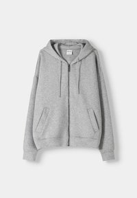 Sudadera con capucha de color gris claro con cremallera, capucha amplia, bolsillos frontales y puños acanalados. Hecha de tela suave y texturizada. Corte clásico y casual.