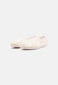 Lace espadrille shoes in off-white, featuring a floral crochet design, rounded toe, and flat rubber sole. Lightweight and breathable material.