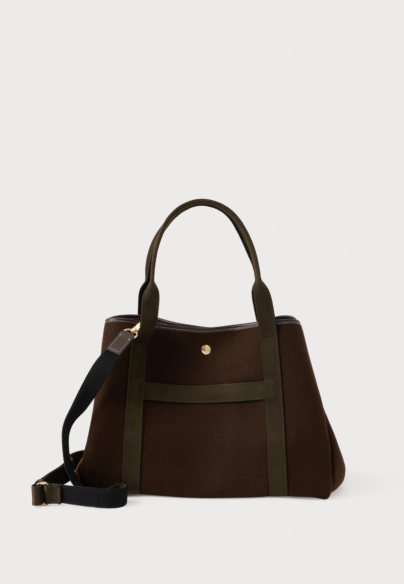 Ορθογώνια καφέ υφασμάτινη τσάντα tote με διπλές λαβές και ρυθμιζόμενο μαύρο ιμάντα ώμου, με μικρό χρυσό κούμπωμα στην μπροστινή τσέπη.