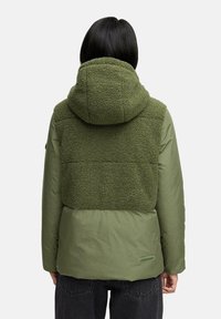 Groene jas met een zachte, textuurachtige fleece achterkant en capuchon, met een gladde onderkant. Eenvoudig ontwerp, met zichtbare stiksels en labeldetails.