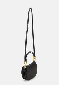 Sac à main en cuir noir avec une forme arrondie, doté d'une longue sangle réglable et d'accents en métal doré. Surface texturée avec des plis.
