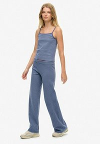 Blauw gestreept tanktop met dunne bandjes, gecombineerd met losse blauw gestreepte broek. Gelaagd stof; beide stukken hebben een casual ontwerp.