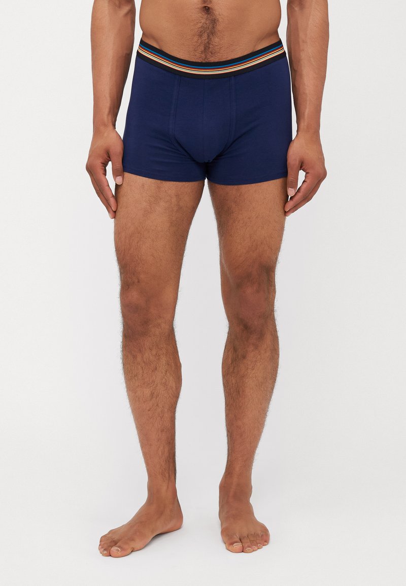 Marineblaue Boxershorts mit figurschmeichelndem Design, elastischem Bund und horizontalen Streifen in Rot, Orange und Gelb, aus weichem Stoff.