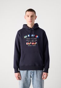Felpa navy con tasca frontale, caratterizzata da colorati segnali nautici e testo. Realizzata in tessuto morbido con polsini e orlo a coste.