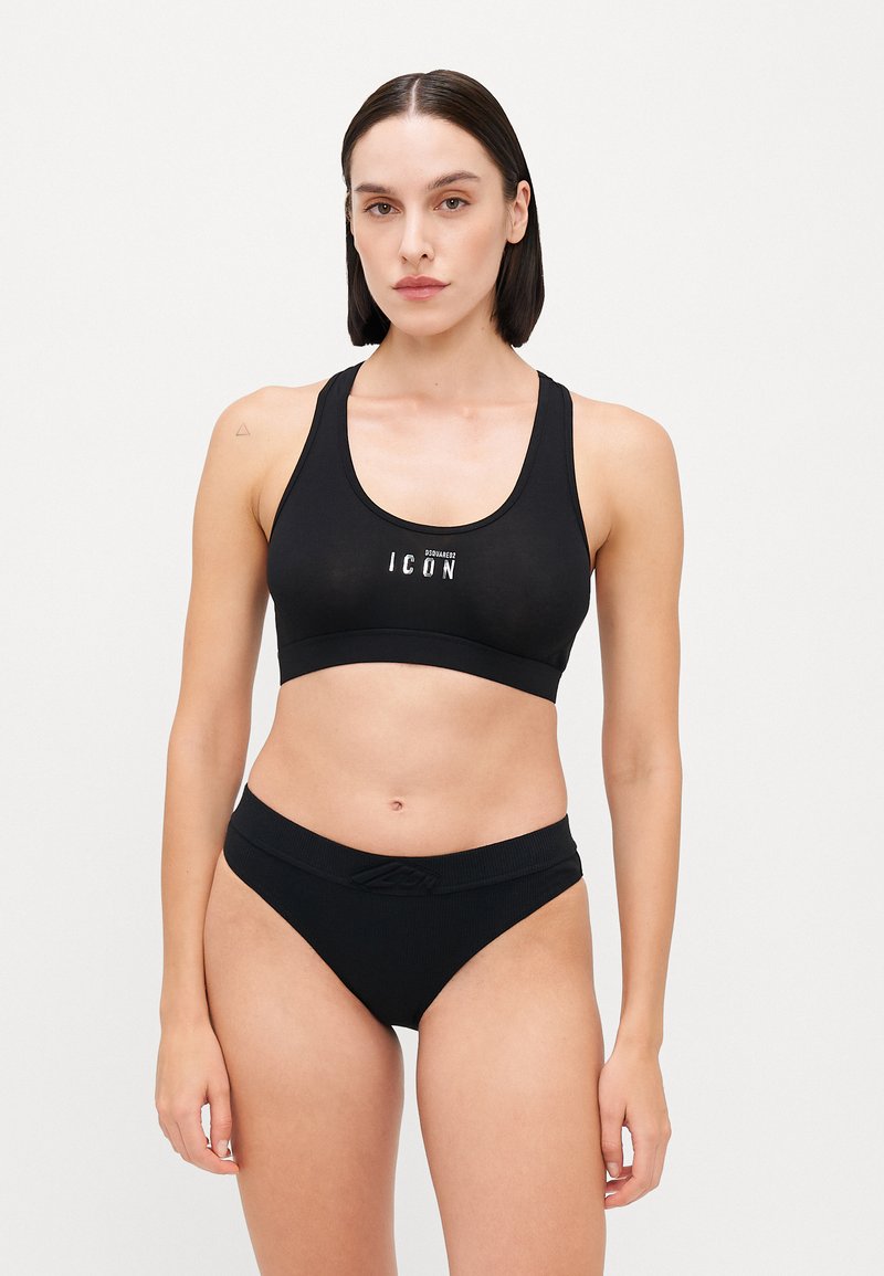 Black sports bra and matching bikini bottoms with ribbed texture. Bra features a wide band and a prominent logo at the center.