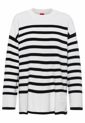 Maglione a righe bianche e nere con una texture a costine, scollo rotondo e maniche lunghe. Presenta un piccolo logo ricamato all'orlo.