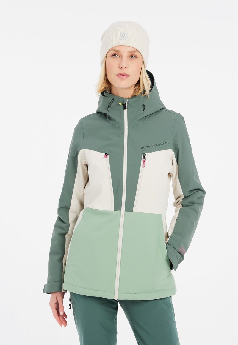 Zeleno-krémová softshell bunda s kapucňou, dvoma prednými vreckami na zips, textúrovanou tkaninou a kontrastnými farebnými blokmi.