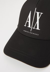 Fekete pamut keverék sapka, strukturális kialakítással, ívelt szélekkel és fehér hímzett "A/X" logóval, alatta "ARMANI EXCHANGE" szöveggel.