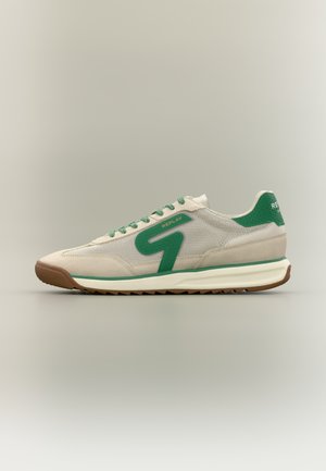 Beige og grønne joggesko med mesh-overside, gummisåle og teksturert hæl. Har grønne skolisser og en stor grønn logo på siden.