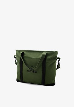 Grüne Canvas-Tragetasche mit schwarzen Griffen und "OTSU"-Logo, mit Fronttasche und abnehmbarem Schultergurt.