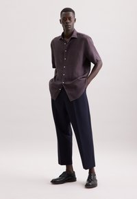 Korte mouwen, donkerpaars linnen shirt met knoopsluiting, gecombineerd met op maat gemaakte marineblauwe broek en zwarte dresschoenen. Gladde textuur en relaxte pasvorm.