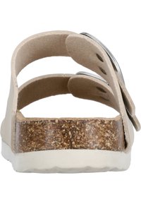 Beige sandal med två justerbara remmar, korksula och vit gummisula. Har en slät yta och runda metallaccenter.