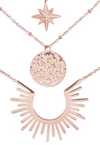 Collana a strati in oro rosa con pendente a stella, un charm circolare testurizzato e un design a ventaglio con raggi allungati.