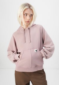 Rosa hettegenser med frontlomme, ribbestrikkede mansjetter og hem, laget av en bomullsblanding, med et lite logomerke på lommen.
