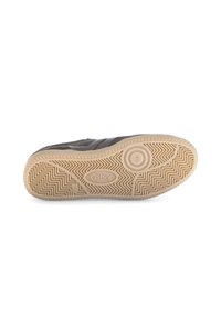 Semelle d'une sneaker noire avec un motif de bande en caoutchouc beige, nom de la marque "Gabor," et marquage de la taille "4 1/2" visible.