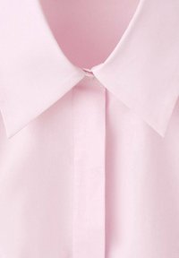 Cămașă roz deschis cu guler, prevăzută cu nasturi în față și confecționată dintr-un material țesut neted cu un luciu subtil.