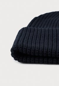 Beanie lavorato a maglia di colore navy, realizzato in filato morbido, con una texture a coste, orlo piegato e una forma leggermente cadente per un calore aggiuntivo.
