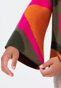 Maglione lavorato a maglia colorato con grandi motivi audaci in rosa, arancio e verde. Maniche a campana e polsini a costine. Tessuto leggero.
