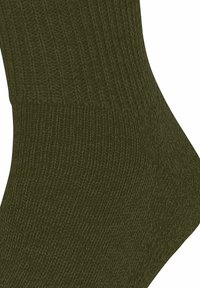 Nahaufnahme einer olivgrünen gerippten Stricksocke, die Textur und Nähdetails zeigt.