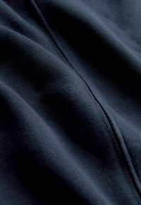 Navy blue fabric with a soft texture and fine knit pattern, featuring visible stitching along the seams and a smooth, slightly reflective surface.