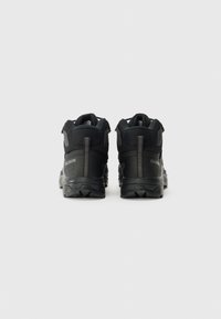 Czarne buty trekkingowe posiadają teksturowaną cholewkę, wyściełany kołnierz oraz wytrzymałą podeszwę. Na tyle widoczny jest logo, a po bokach znajdują się zamki błyskawiczne.