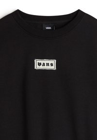 Sweatshirt noir en coton avec un col rond, présentant un logo "Vans" brodé en blanc sur un patch rectangulaire au niveau de la poitrine.