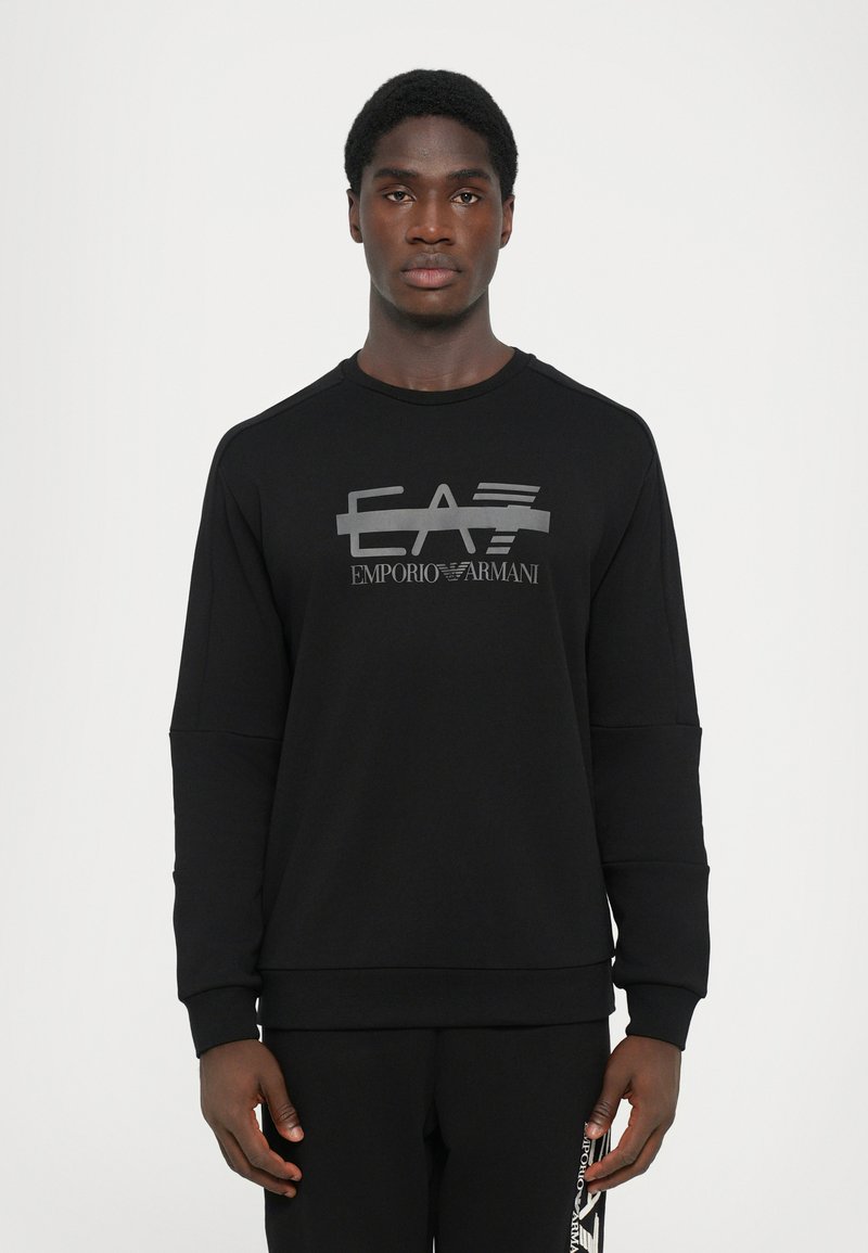 Moleton preto com um logótipo cinza brilhante "EA7 Emporio Armani" no peito, feito de um tecido suave e texturizado com um corte descontraído.