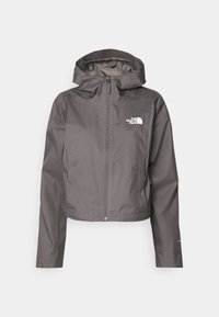 Szara wodoodporna kurtka z kapturem, pełnym zamkiem błyskawicznym, dwoma bocznymi kieszeniami oraz białym logo na lewej piersi. Gładka faktura i krótki fason.