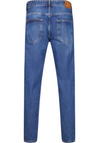 Jeans de mezclilla azul claro con corte recto, cinco bolsillos y un parche de cuero marrón en la cintura, con una textura sutil.