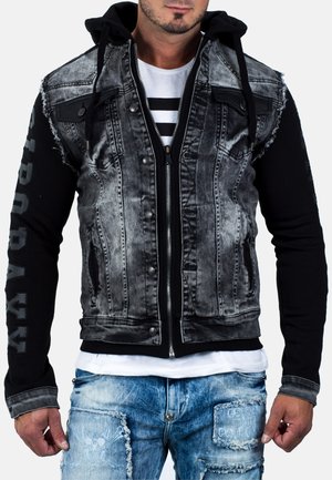 Giacca da uomo che combina un davanti in denim nero sbiadito con un retro e maniche in jersey nero, dotata di cappuccio, cerniere e bordi sfilacciati.