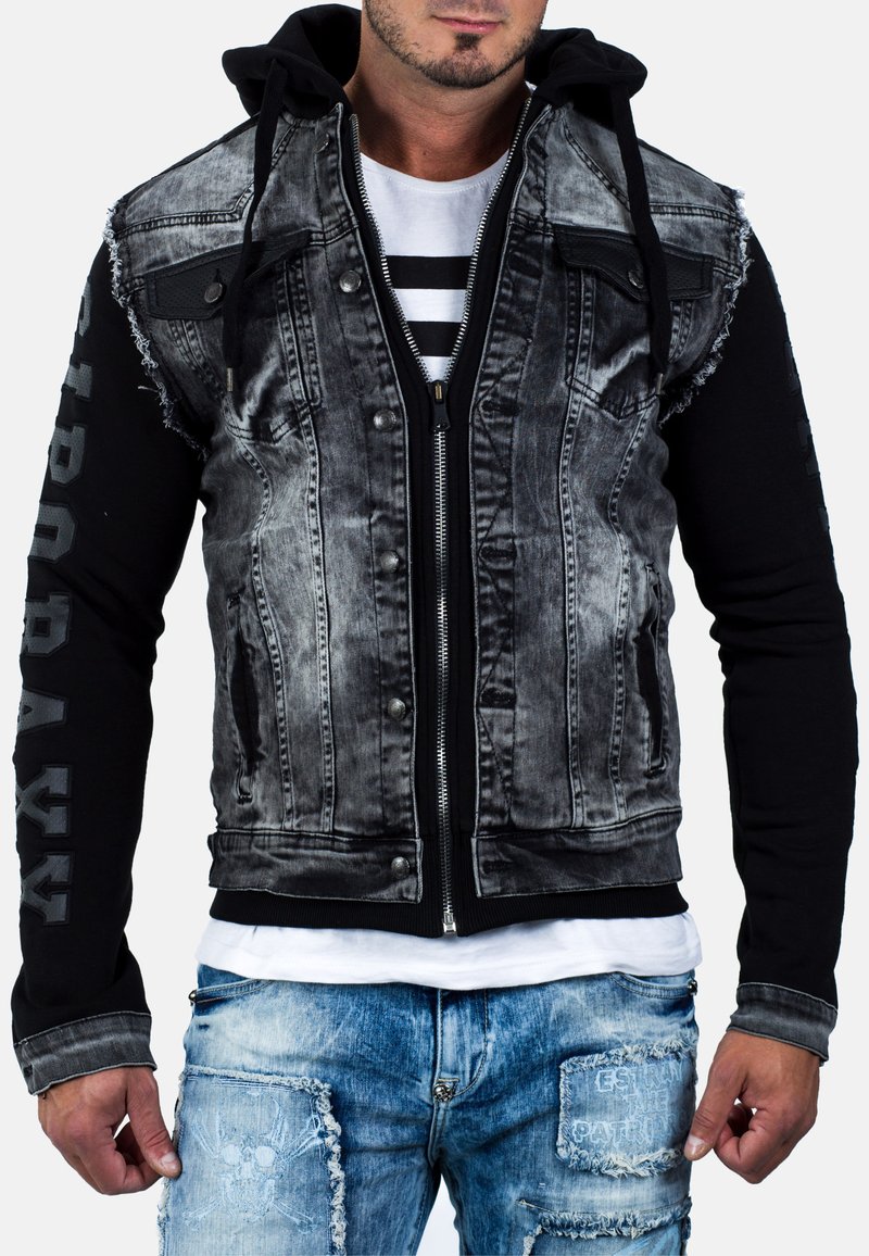 Giacca da uomo che combina un davanti in denim nero sbiadito con un retro e maniche in jersey nero, dotata di cappuccio, cerniere e bordi sfilacciati.