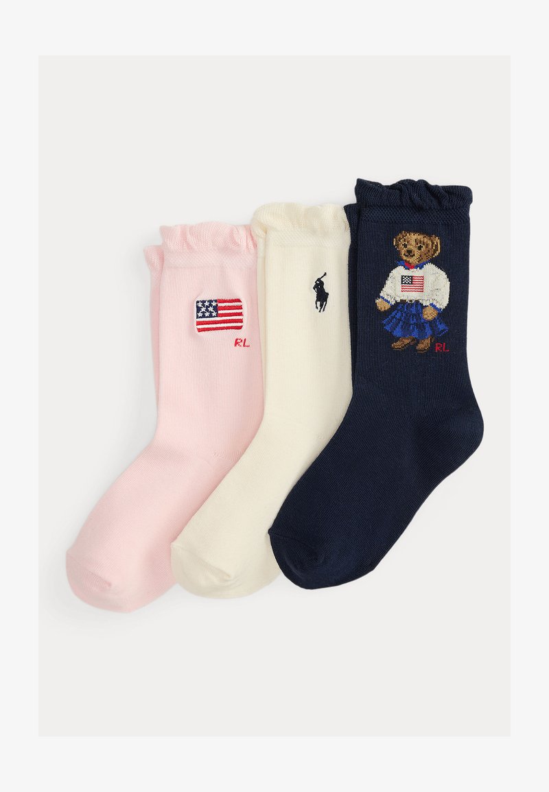 Τρία γυναικεία καλτσάκια με βολάν στην κορυφή σε ροζ, κρεμ και ναυτικό μπλε, το καθένα με κεντημένα σχέδια με θέμα την Αμερική και αρχικά λογότυπα Ralph Lauren.