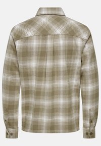Camisa de franela a cuadros en verde y blanco; de mangas largas, con puños de botón, cuello y un acabado texturizado con un aspecto ligeramente cepillado.