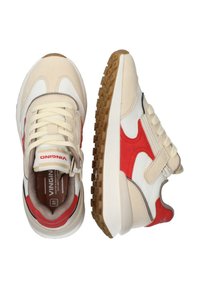 Sneakers atletici beige e bianchi con accenti rossi, suola in gomma testurizzata, linguetta imbottita e lacci piatti. Design leggero.
