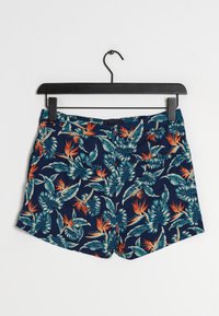 Navy shorts met een tropisch patroon van groene bladeren en oranje bloemen. Gemaakt van stof, met een platte tailleband en zonder zichtbare zakken.