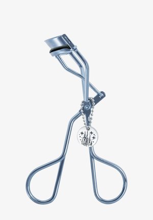 Metal eyelash curler with black rubber pad and small round charm featuring a castle and stars on a ball chain.